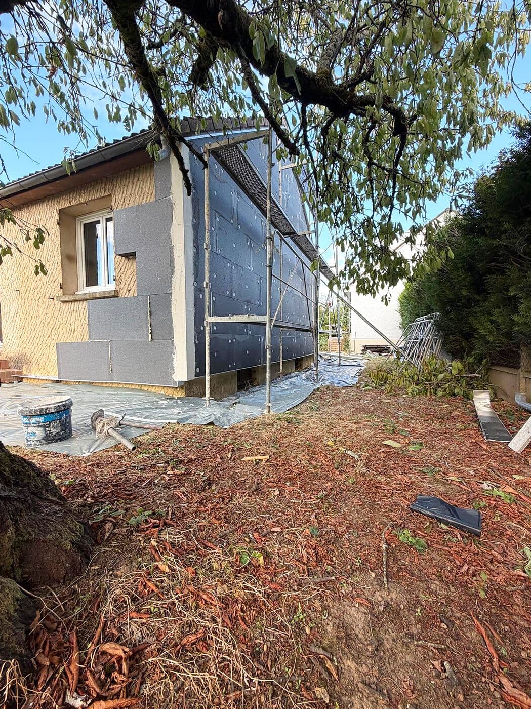 Façade d'origine en cours de recouvrement par l'isolant, échafaudage en place